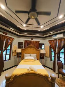 a bedroom with a large bed with a ceiling fan at Negros Haven Seaside Resort in Camanjac