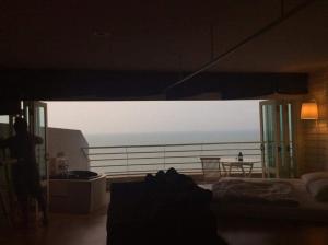 a room with a bed and a view of the ocean at Sandy Beach E18 in Cha Am