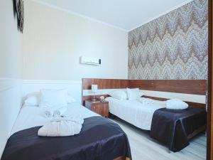 a hotel room with two beds with towels at Holiday Beach Budapest Wellness Hotel with Sauna Park in Budapest