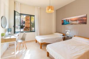 a bedroom with two beds and a desk and a table at El Oasis La Casita 1 Bajo A in Fuente Alamo +16 photos