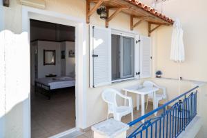 a balcony with a table and chairs on a house at Elli Studios & Apartments in Marathokampos