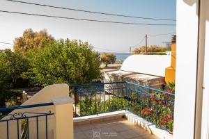 a balcony with a blue railing and a view of the ocean at Elli Studios & Apartments in Marathokampos