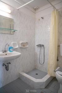 a bathroom with a shower and a sink and a toilet at Elli Studios & Apartments in Marathokampos