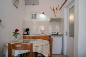 a small kitchen with a table and a sink at Elli Studios & Apartments in Marathokampos