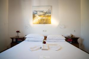 a bedroom with two beds with towels and a painting at Elli Studios & Apartments in Marathokampos