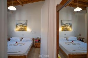 a bedroom with two beds and two pictures on the wall at Elli Studios & Apartments in Marathokampos
