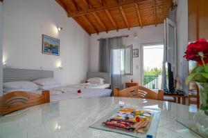 a hotel room with two beds and a table with a tray of food at Elli Studios & Apartments in Marathokampos