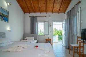 a hotel room with two beds and a television at Elli Studios & Apartments in Marathokampos