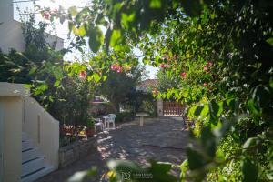 a garden with a table and chairs and pink flowers at Elli Studios & Apartments in Marathokampos