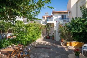 a courtyard of a house with a table and chairs at Elli Studios & Apartments in Marathokampos