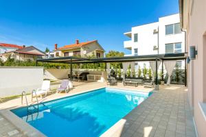 a swimming pool in front of a house at Villa Suzy in Medulin