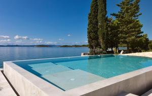 a swimming pool next to a body of water at Awesome Home In Zdrelac in Ždrelac +14 photos
