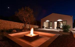 a fire pit in front of a house at night at Awesome Home In Zdrelac in Ždrelac