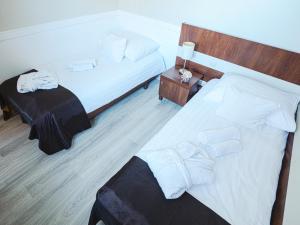 a hotel room with two beds with white sheets at Holiday Beach Budapest Wellness Hotel with Sauna Park in Budapest