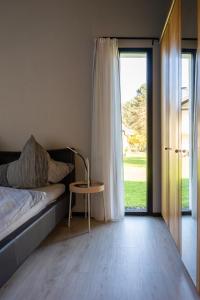 Un dormitorio con una cama y una mesa y una ventana. en Apartment Anna - FeWo 56qm2 - Hausen-Wied, en Hausen-Wied
