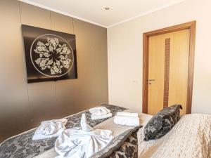 a bedroom with a bed with towels on it at Holiday Beach Budapest Wellness Hotel with Sauna Park in Budapest