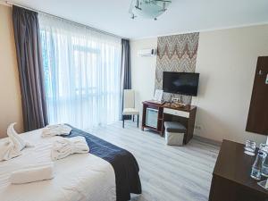 a hotel room with a bed and a television at Holiday Beach Budapest Wellness Hotel with Sauna Park in Budapest
