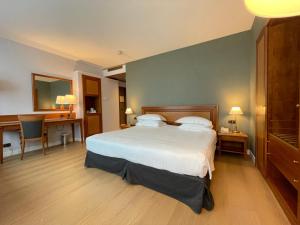 a hotel room with a bed and a desk and a desk at Crowne Plaza Milan Linate by IHG in San Donato Milanese