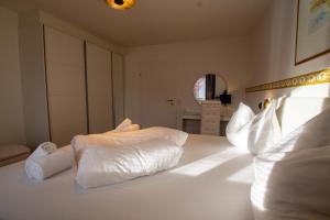 białe łóżko z białymi poduszkami w obiekcie Panorama Apartments - Steinbock Lodges w mieście Zell am See