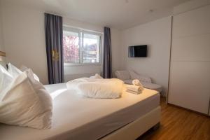 sypialnia z łóżkiem z białą pościelą i oknem w obiekcie Panorama Apartments - Steinbock Lodges w mieście Zell am See
