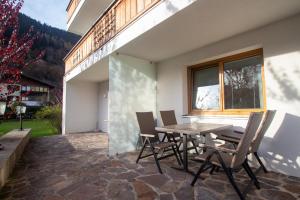 taras ze stołem, krzesłami i oknem w obiekcie Panorama Apartments - Steinbock Lodges w mieście Zell am See