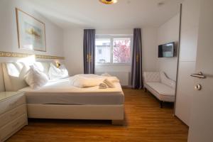 sypialnia z łóżkiem, krzesłem i oknem w obiekcie Panorama Apartments - Steinbock Lodges w mieście Zell am See