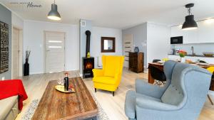 a living room with yellow chairs and a table at Wonder Home - Domki górskie z kominkami na kameralnym osiedlu - plac zabaw na terenie kompleksu in Karpacz +118 photos