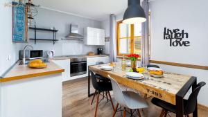 a kitchen with a large wooden table and chairs at Wonder Home - Domki górskie z kominkami na kameralnym osiedlu - plac zabaw na terenie kompleksu in Karpacz