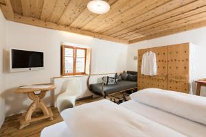 sypialnia z 2 łóżkami, biurkiem i telewizorem w obiekcie Hotel & Gourmetwirtshaus Kirchenwirt seit 1326 w mieście Leogang