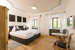 sypialnia z dwoma łóżkami i stołem w obiekcie Hotel & Gourmetwirtshaus Kirchenwirt seit 1326 w mieście Leogang