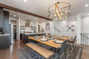 a dining room with a table and a kitchen at 6-Bedroom House, Sleeps 25, Tesla Friendly, New Build Near PCMR, Rooftop Spa in Park City