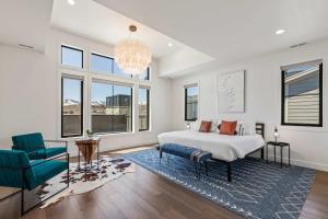 a bedroom with a bed and a chair and windows at 6-Bedroom House, Sleeps 25, Tesla Friendly, New Build Near PCMR, Rooftop Spa in Park City