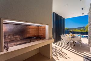 a patio with a fireplace and a table and chairs at "Casa Mia" Luxury villa with heated swimming pool with jacuzzi in Šestanovac