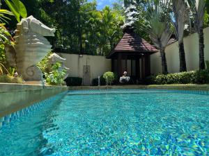 a swimming pool with a gazebo in a yard at Sanya beach sweet house in Luoyushangcun