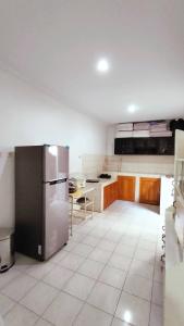 a large kitchen with a stainless steel refrigerator at Kamiliya Homestay in Ngabean +10 photos