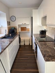 a kitchen with white cabinets and a counter top at Taymount Cottage in Caputh