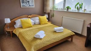 a bedroom with a bed with towels on it at Pension Arabela in Harrachov