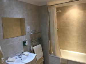 ein Badezimmer mit Waschbecken und Dusche in der Unterkunft Coach House Wroxham Holiday Cottage in Wroxham