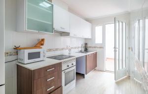 a kitchen with white cabinets and a microwave at Awesome Home In San Juan De Los Terrer in San Juan de los Terreros