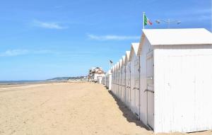 a white fence on a beach next to the ocean at Beautiful Home In Auberville With Wifi in Auberville +25 photos
