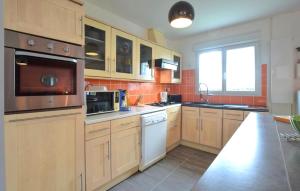 a large kitchen with wooden cabinets and appliances at Beautiful Home In Auberville With Wifi in Auberville
