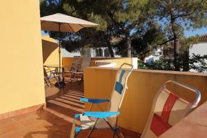 un patio con tavolo, sedie e ombrellone di Islantilla Urbasur 1 dormitorio y terraza a Islantilla