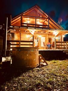 a wooden house with lights on the front of it at Hillside Praid in Praid