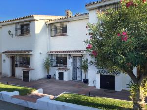 een wit huis met een boom ervoor bij Carmen Casa Helena in Nerja