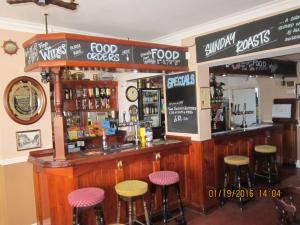 a bar with bar stools in a restaurant at Queen Mary Inn in Poole