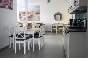 a kitchen with a white table and chairs at CDP Apartmanok in Alsóörs