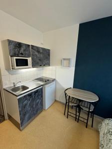 a small kitchen with a sink and a table at Studio au coeur de Valence 22 in Valence
