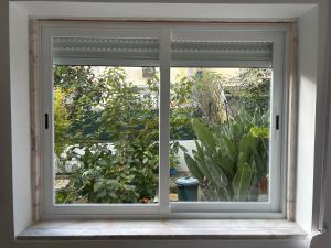 an open window with a view of a garden at Casinha da Portela in Sintra