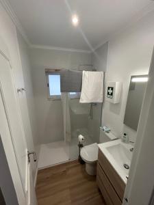 a white bathroom with a toilet and a sink at Casinha da Portela in Sintra +9 photos