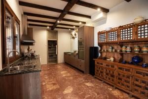a large kitchen with wooden cabinets and a sink at Teralba 1 Casa Rural in La Calzada de Oropesa